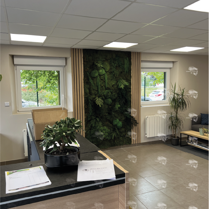 Bureau moderne avec un mur végétal, fenêtres et mobilier sobre.