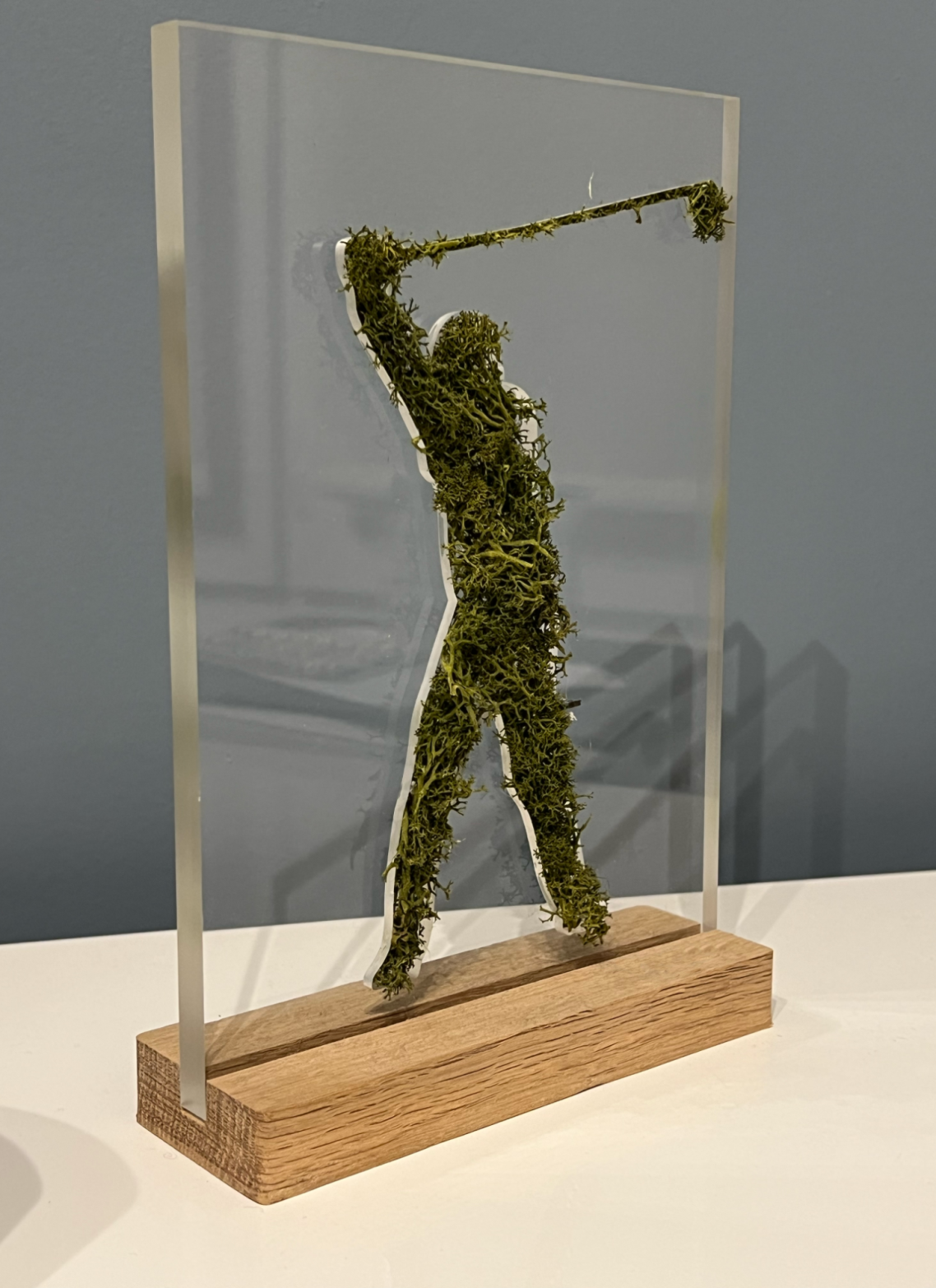 Silhouette d'un golfeur en mousse sur une base en bois, transparent en arrière-plan.