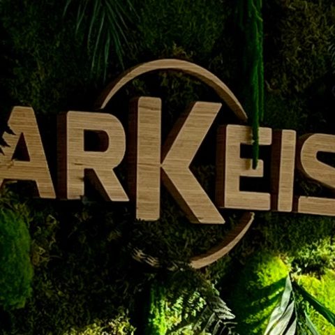 Un homme travaille sur un mur végétal avec le logo "Eiffage" en arrière-plan.