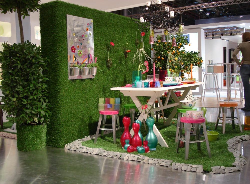 Plantes suspendues au plafond dans un café lumineux avec des murs décorés de photos.