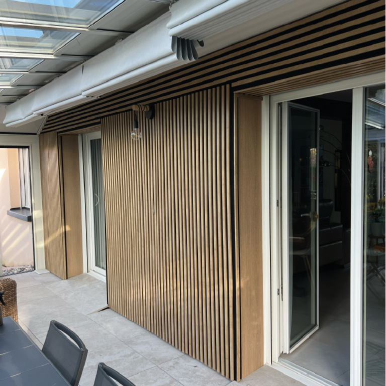 Un homme travaille sur un mur végétal avec le logo "Eiffage" en arrière-plan.