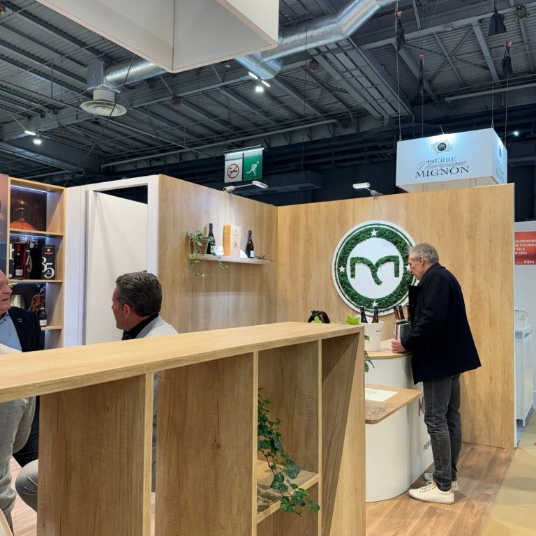 Un homme travaille sur un mur végétal avec le logo "Eiffage" en arrière-plan.