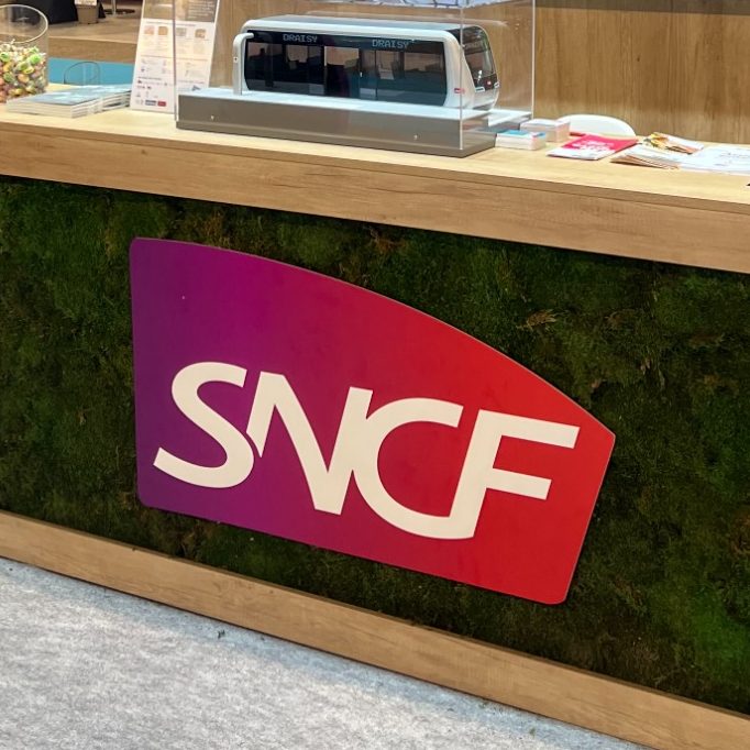 Un homme travaille sur un mur végétal avec le logo "Eiffage" en arrière-plan.