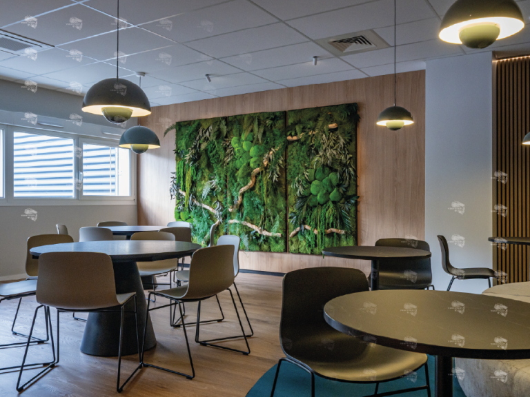 Salle à manger moderne avec tables rondes, chaises et un mur végétal décoratif.