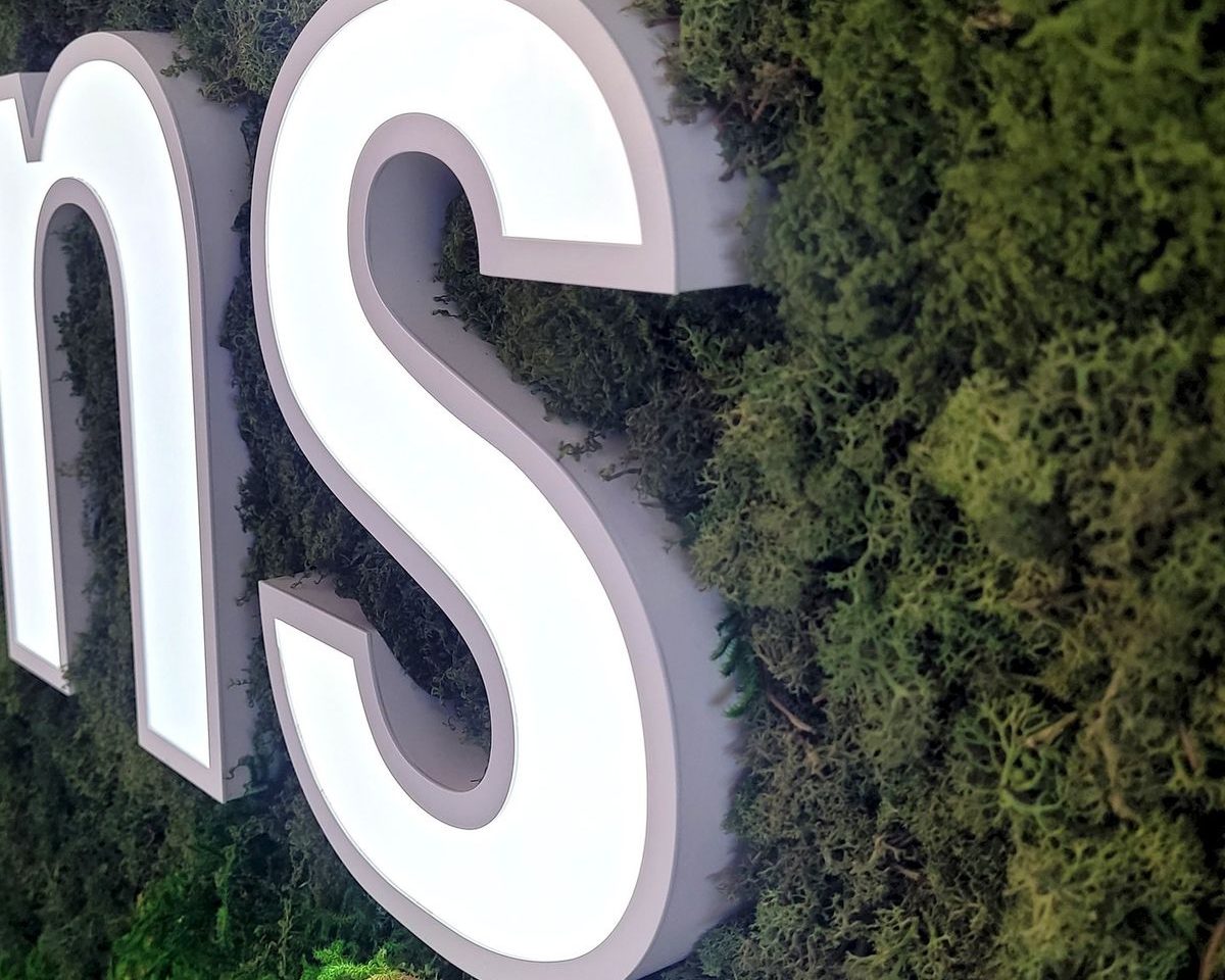 Lettrage en relief sur un fond de mousse verte.