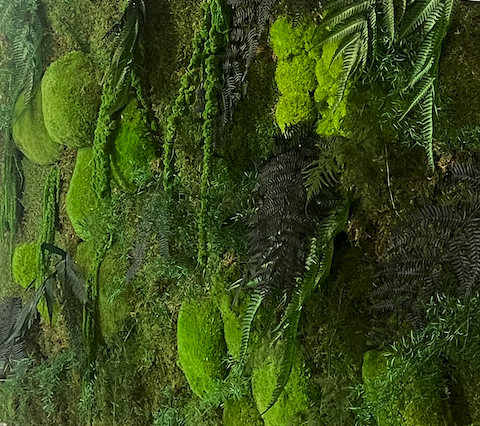 Un homme travaille sur un mur végétal avec le logo "Eiffage" en arrière-plan.