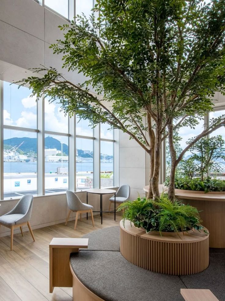 Espace lumineux avec des plantes, des sièges modernes et une vue sur les montagnes.