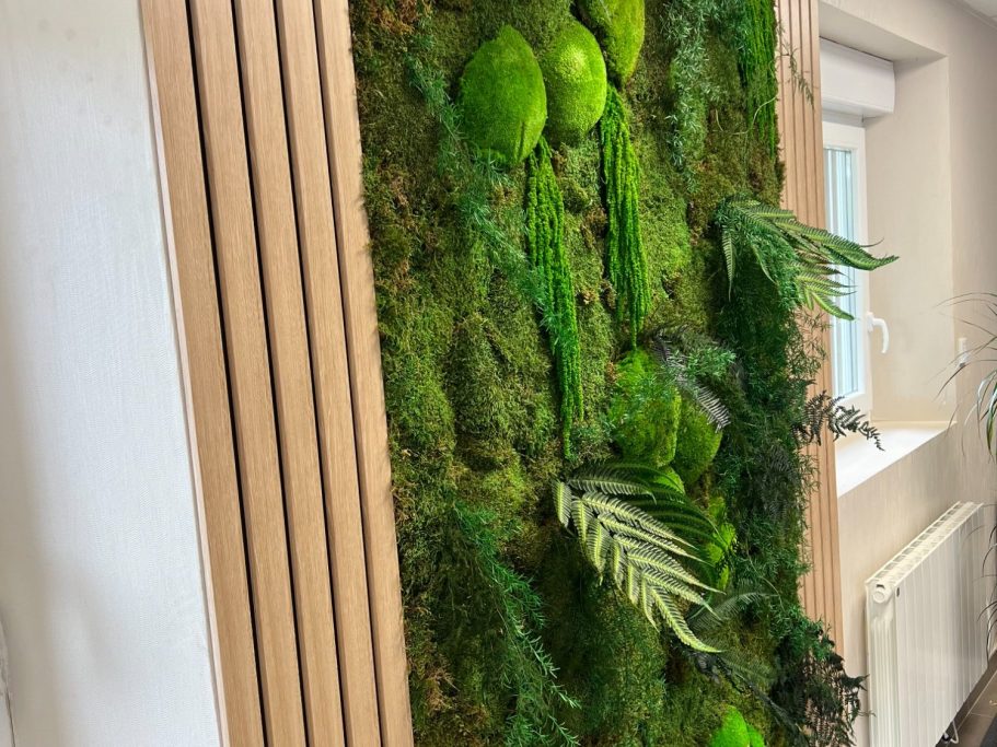 Mur végétal avec mousse, plantes vertes et touches de bois.