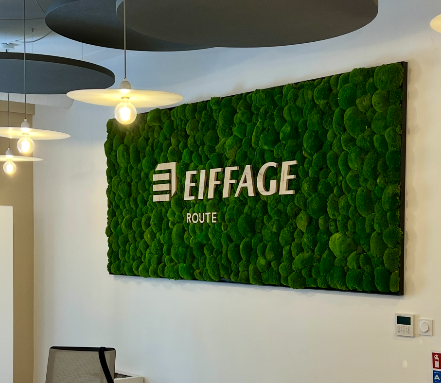 Logo d'Eiffage sur un mur végétal, décoré de mousse verte.