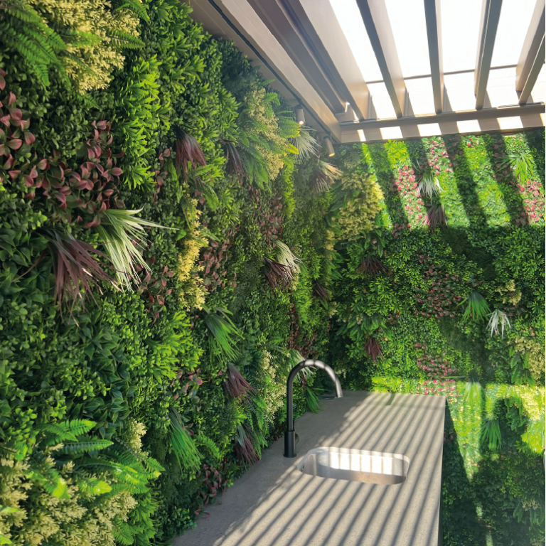 Un homme travaille sur un mur végétal avec le logo "Eiffage" en arrière-plan.