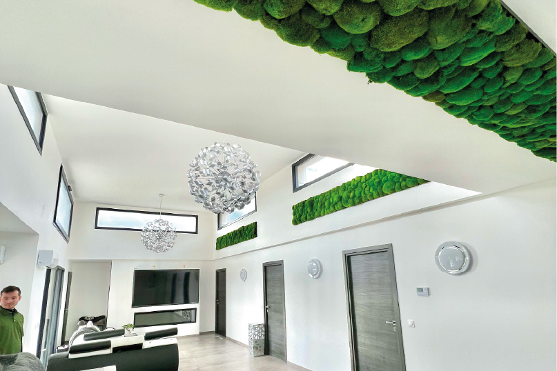 Stand d'exposition avec un logo au mur et deux personnes en discussion.