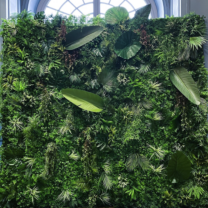 Mur végétal luxueux avec des feuilles et des plantes vertes variées.